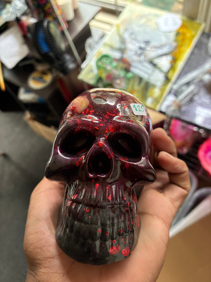 Handmade bloody purple and black epoxy resin skull with red splatter details, front view