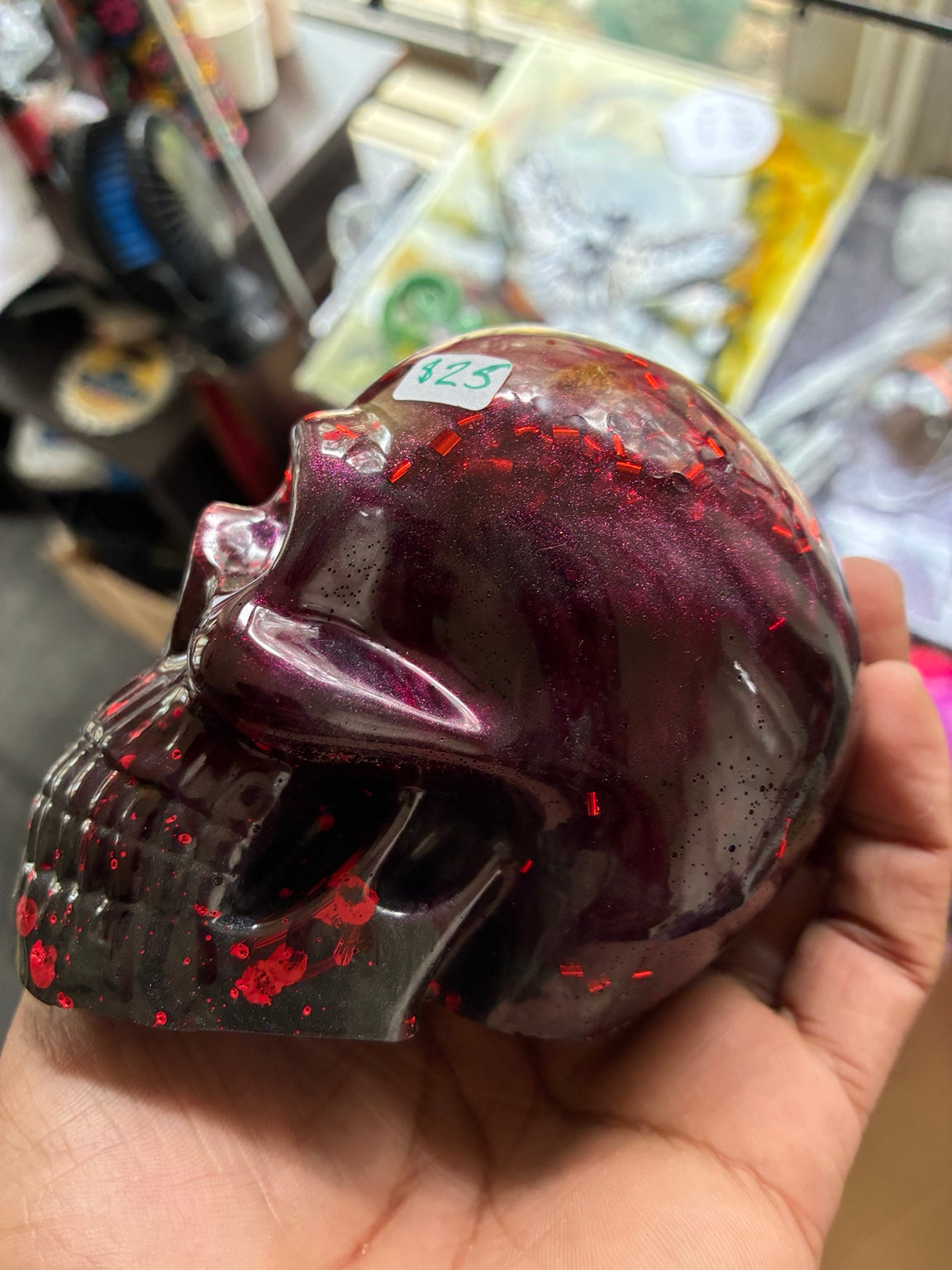 Handmade bloody purple and black epoxy resin skull with red glitter, left side view