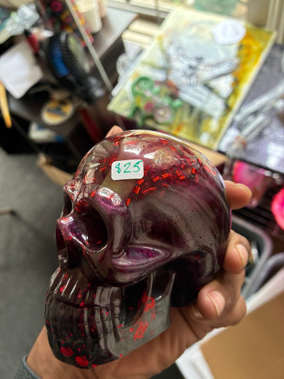 Handmade bloody purple and black epoxy resin skull with red splatter and glitter, three-quarter view
