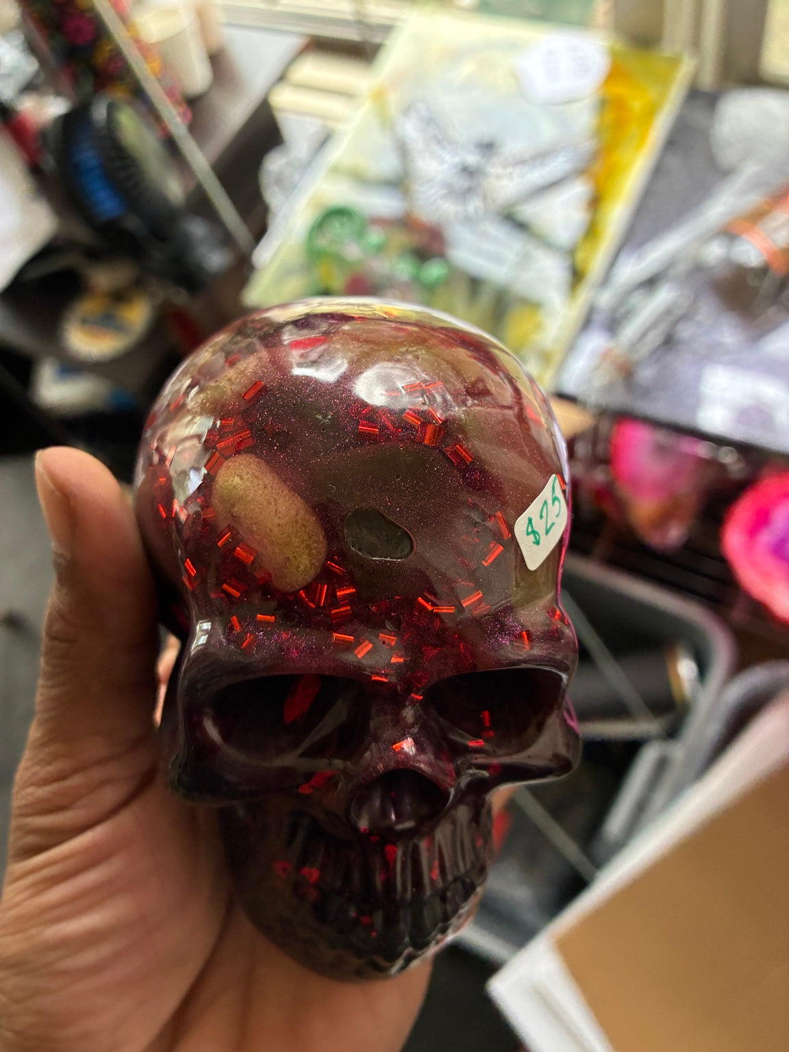 Top view of handmade purple black epoxy resin skull showing clear resin and red glitter details