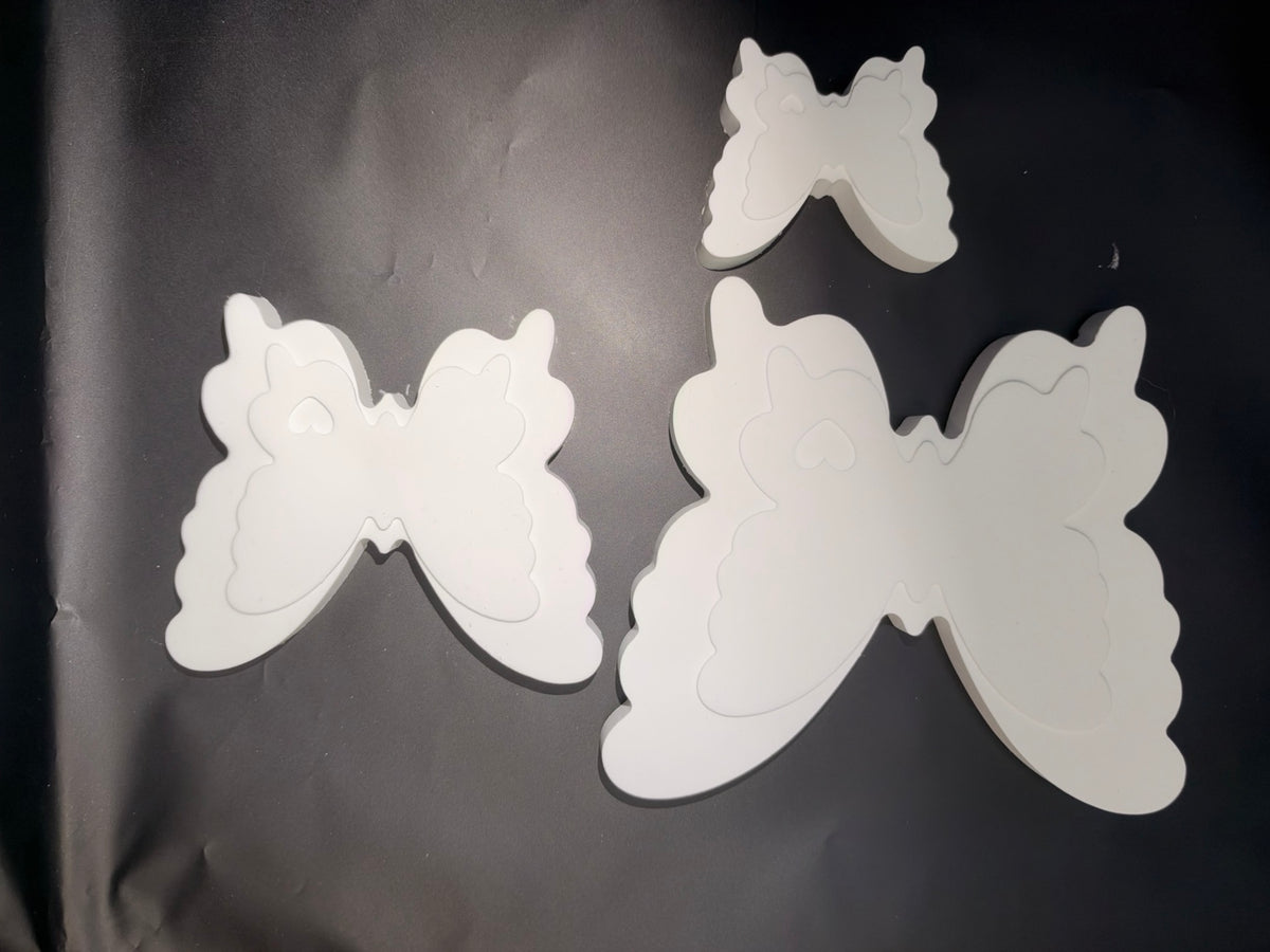 Three ceramic resin butterfly paint kit pieces laid flat