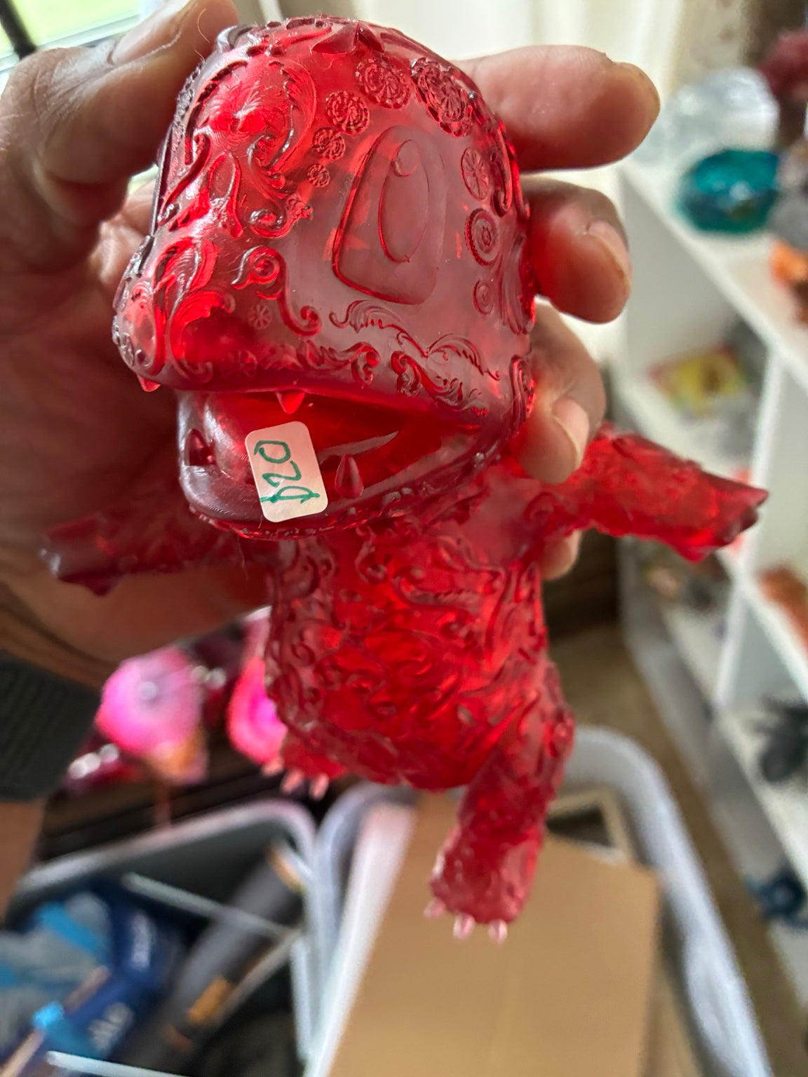 Close-up of red translucent Charmander-inspired UV resin 3D printed figure with decorative pattern