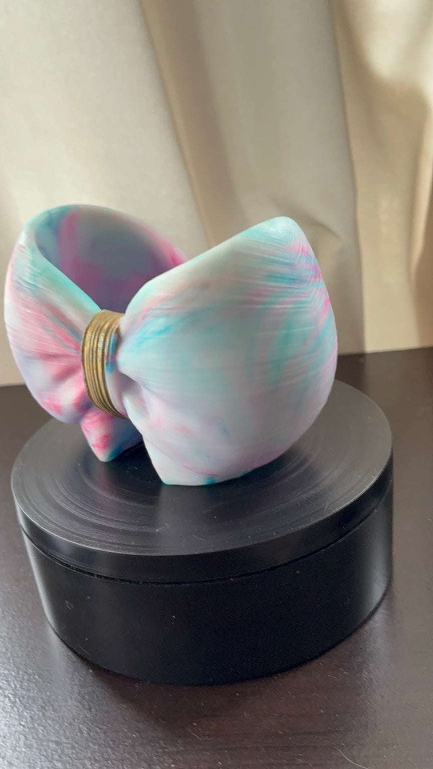 Pastel resin bow holder shown from a front side angle