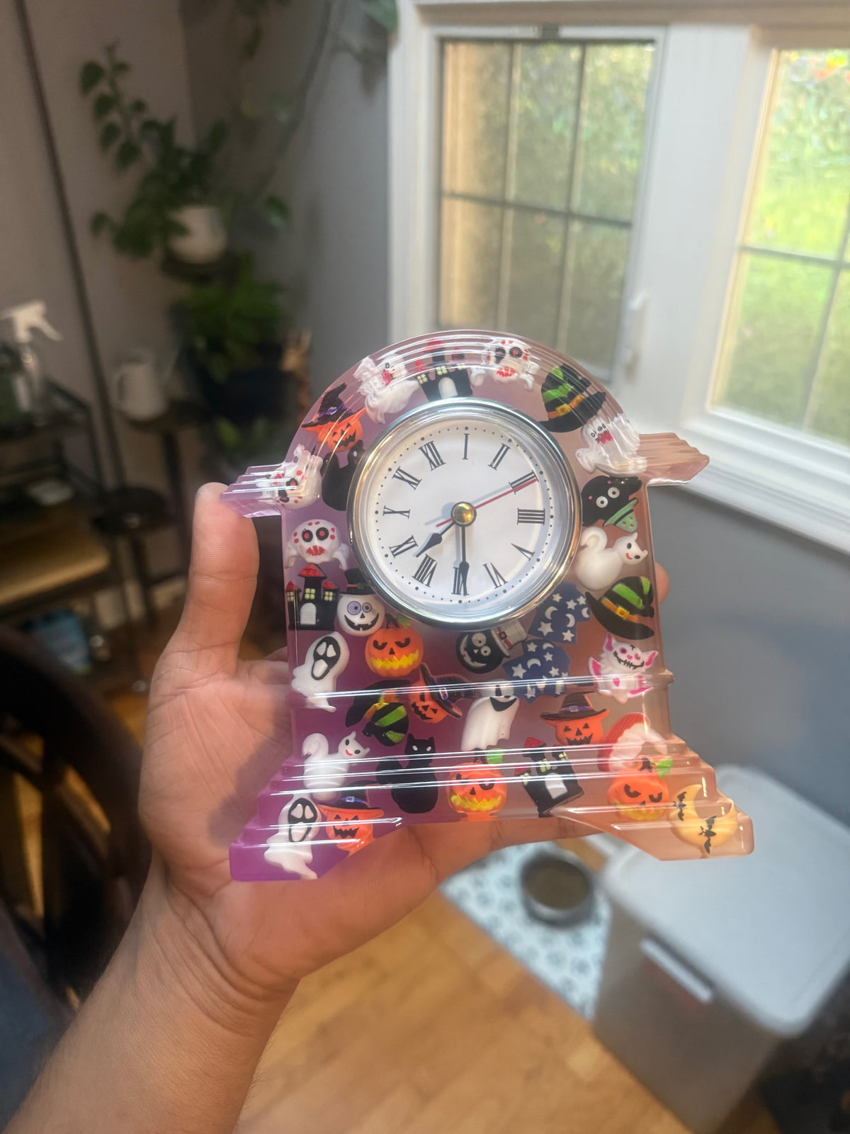 Handheld view of Halloween epoxy resin clock with embedded spooky charms