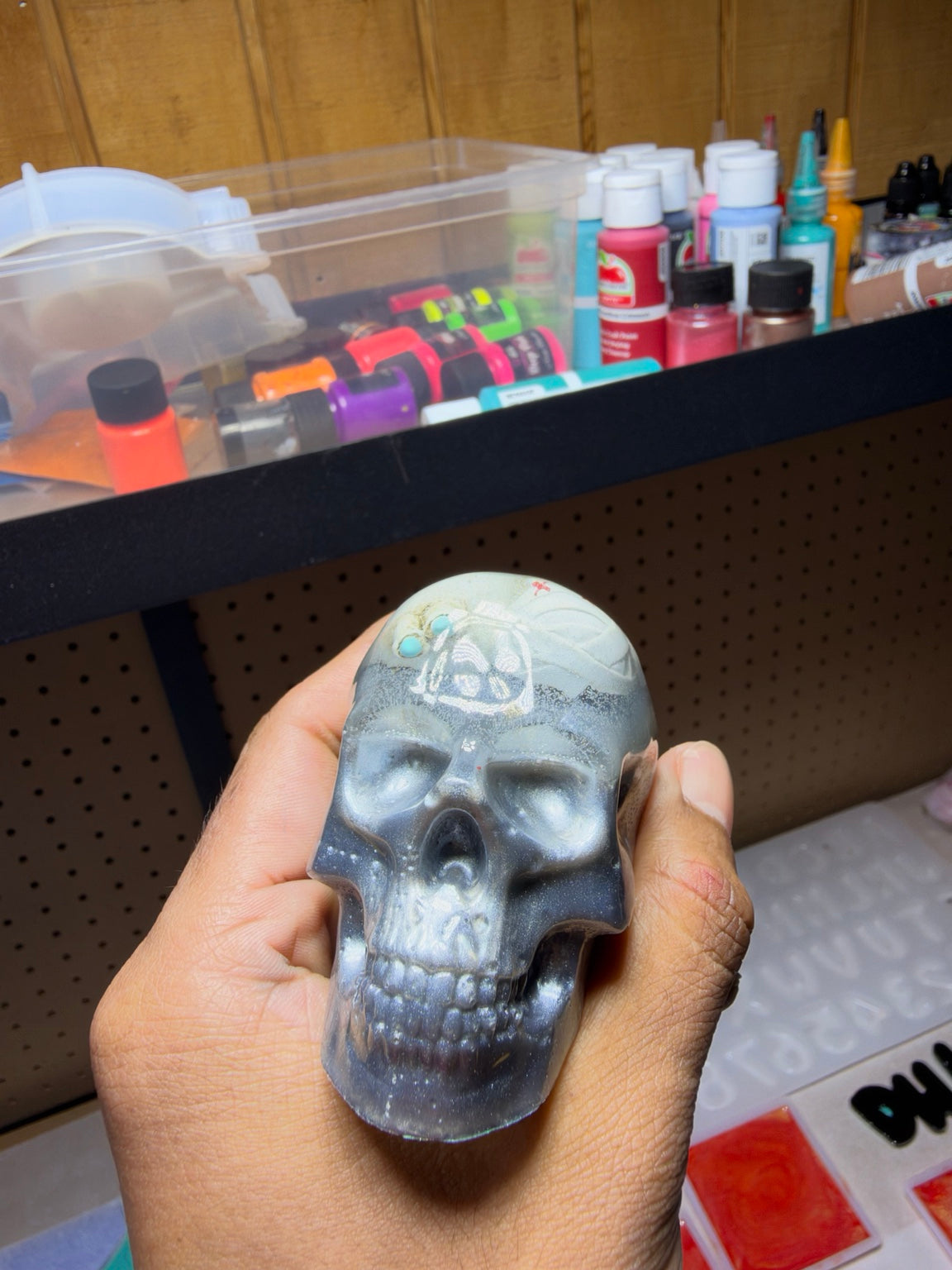 Front view of medium handmade resin skull with embedded skeleton detail