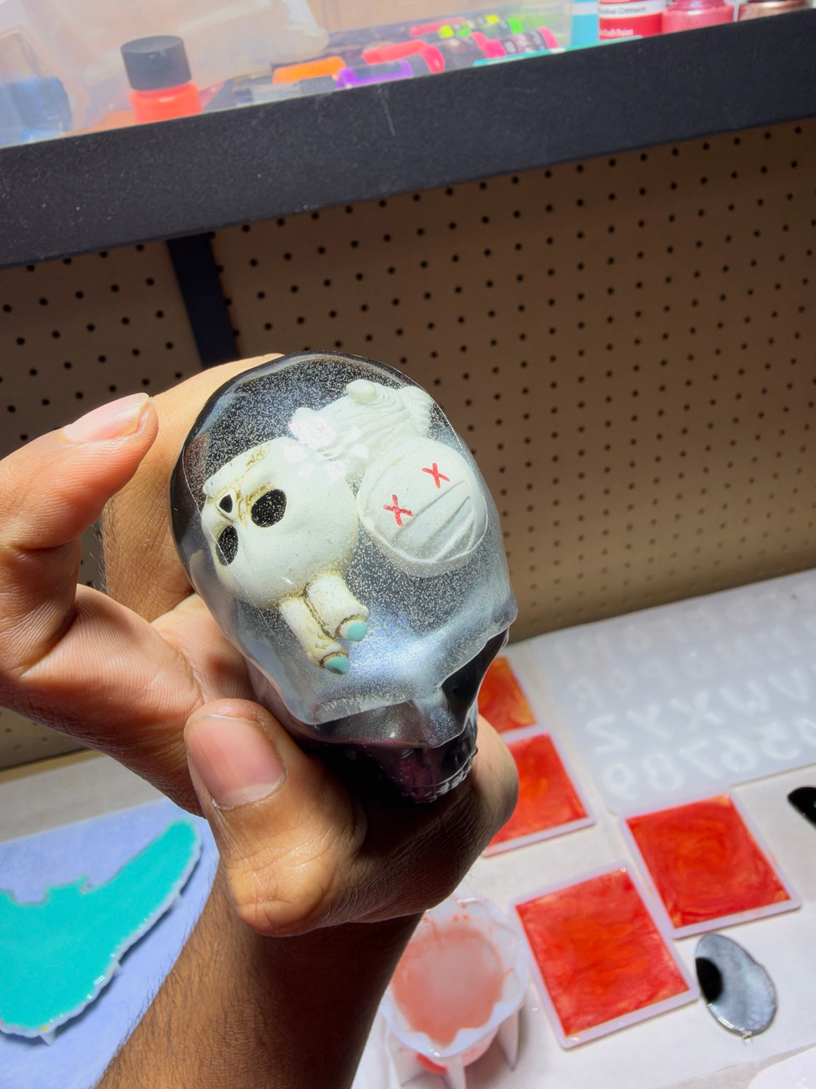 Top and back view showing embedded skeleton and coffin inside resin skull