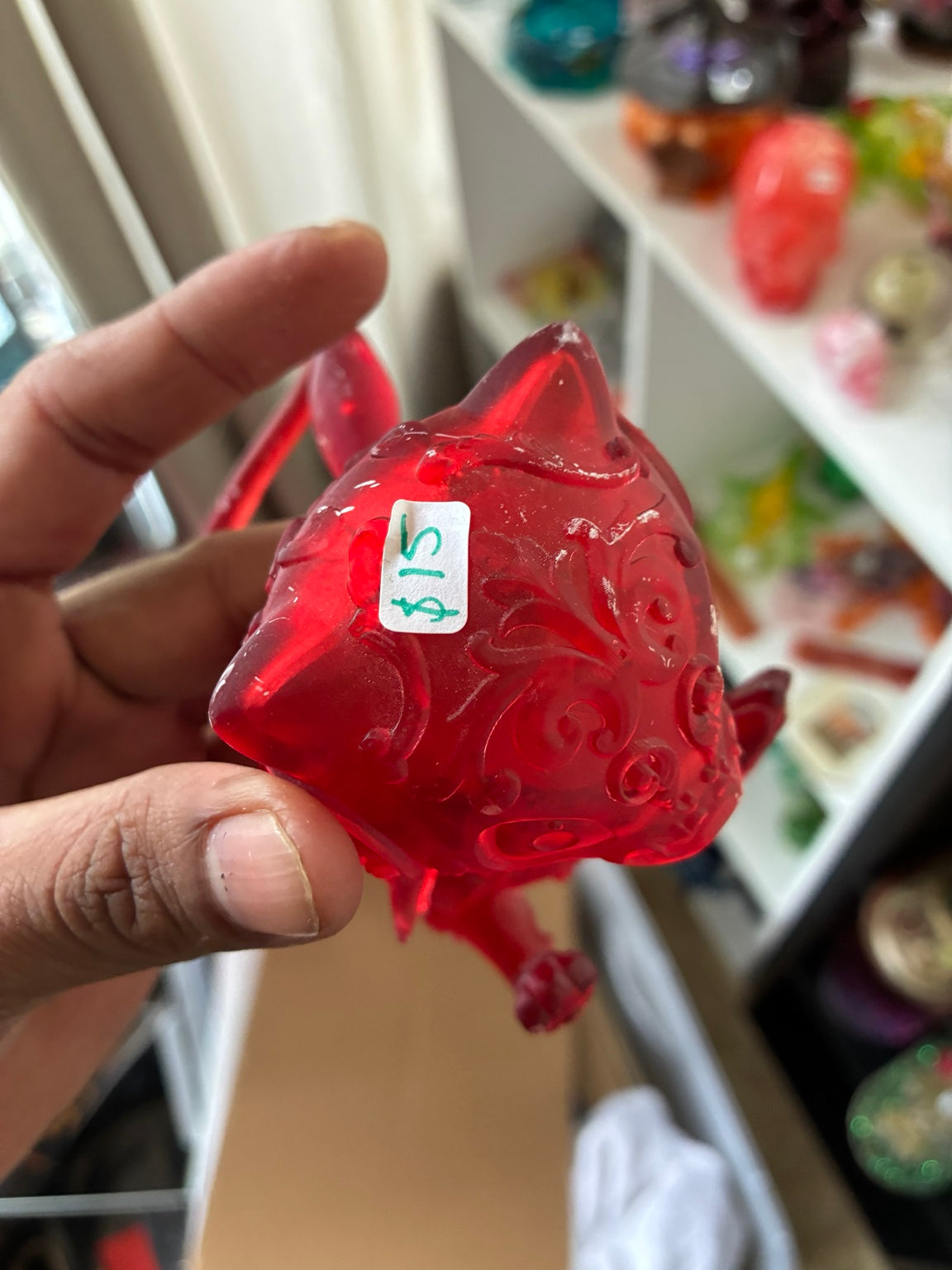 Close-up of red translucent Mew-inspired UV resin 3D printed figurine with decorative pattern